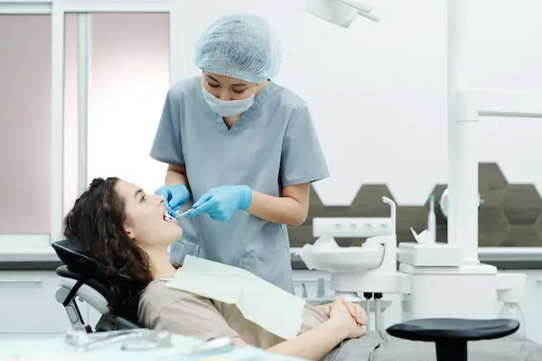 Odontóloga revisando la salud y el color de los dientes de una paciente