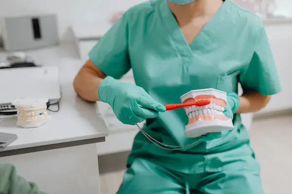 Odontólogo enseñando una técnica de cepillado para mantener una buena higiene dental
