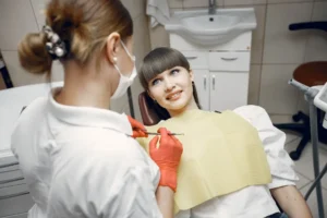 Odontólogo evaluando los dientes de una paciente durante una consulta dental